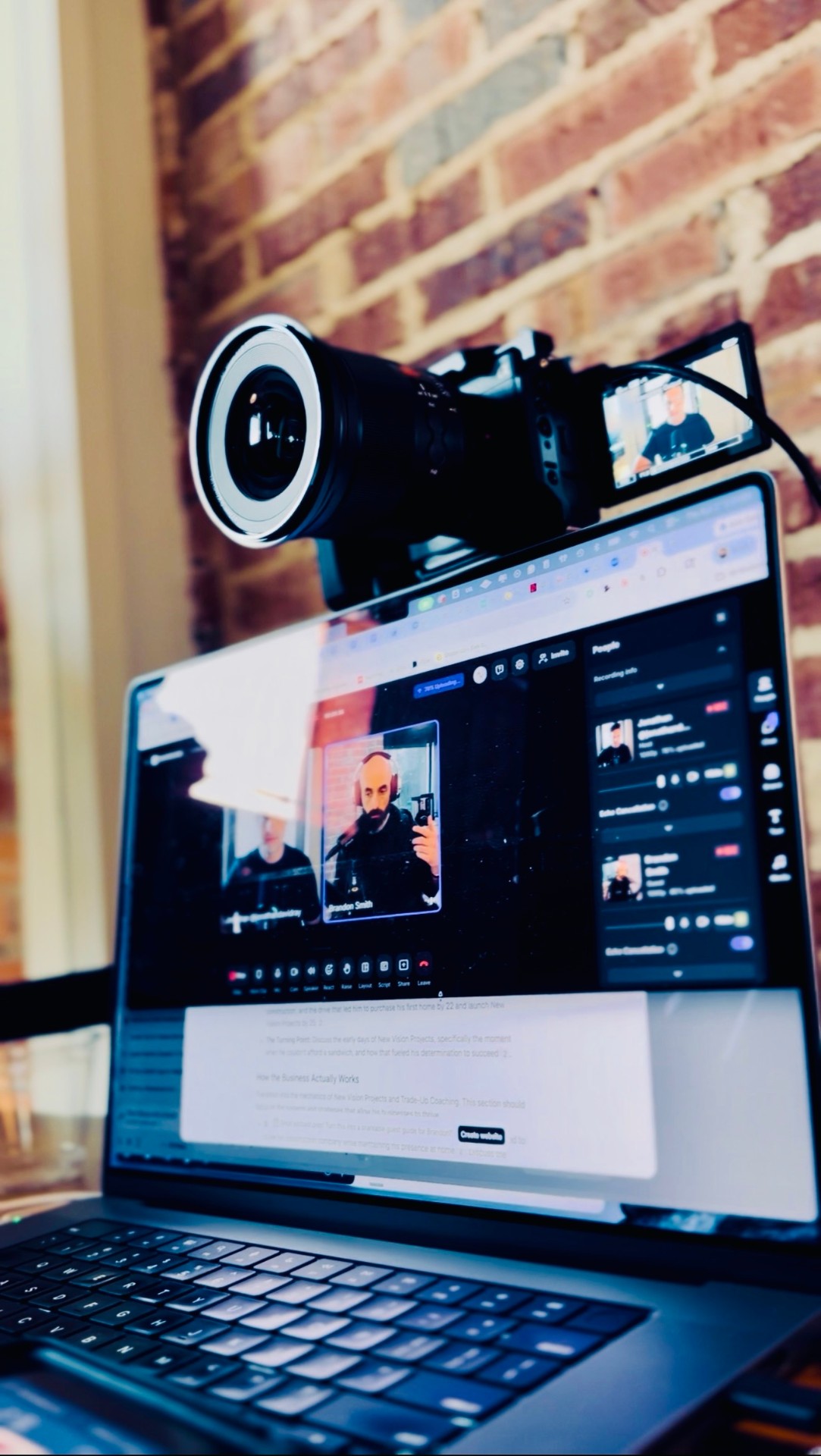 Jonathan David Ray's recording setup — laptop on a brick-wall studio mid strategy call with a creative client